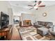 Cozy living room with hardwood floors, ceiling fan, fireplace, and comfortable seating at 11 Pecan Course Loop, Ocala, FL 34472