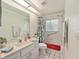 Bright bathroom with a shower featuring a decorative curtain, vanity, and white tile at 11051 Sw 73Rd Ct, Ocala, FL 34476