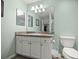 Bright bathroom features a vanity with granite top and lots of lighting at 1204 Flamingo Pl, The Villages, FL 32162