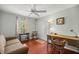 Bright bedroom features hardwood floors, ceiling fan, closet, and flexible space for work or relaxation at 1204 Flamingo Pl, The Villages, FL 32162