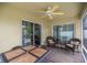 Covered patio with ceiling fan, seating, and sliding glass doors to interior at 1204 Flamingo Pl, The Villages, FL 32162