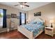 Bright bedroom with hardwood floors, a ceiling fan, and a white wooden bed frame at 12169 Se 172Nd Ln, Summerfield, FL 34491