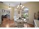 Bright dining area with a round table, hardwood floors, and natural light from the large window at 12169 Se 172Nd Ln, Summerfield, FL 34491