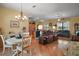 Spacious living area with hardwood floors seamlessly connecting to the open kitchen and dining space at 12169 Se 172Nd Ln, Summerfield, FL 34491