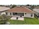 Rear exterior view of home features a large yard, patio, grill and screened in porch at 12169 Se 172Nd Ln, Summerfield, FL 34491