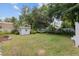 Spacious backyard featuring a lush lawn, white storage shed, privacy fence and a relaxing hammock under the trees at 12335 Se 130Th Ct, Ocklawaha, FL 32179