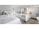 Bright bedroom with twin beds, white wicker frames, and open access to a bathroom and hall at 12335 Se 130Th Ct, Ocklawaha, FL 32179