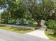 Lovely home featuring a long driveway and lush landscaping, enhanced by the shade of mature trees at 12335 Se 130Th Ct, Ocklawaha, FL 32179