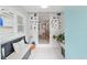 Bright foyer with white tile floors, a comfortable bench, and decorative Gathering photos enhancing a cozy atmosphere at 12335 Se 130Th Ct, Ocklawaha, FL 32179