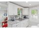 Bright kitchen with white cabinets, stainless sink, and a view to the adjacent dining area at 12335 Se 130Th Ct, Ocklawaha, FL 32179