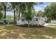 Exterior view of home with a lush lawn, bright blue front door and seating area at 12335 Se 130Th Ct, Ocklawaha, FL 32179