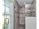 Modern shower showcasing a tile design, glass door, and natural light from a window at 12392 Sw 85 Pl, Dunnellon, FL 34432