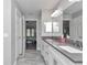 Bathroom with double sink vanity, framed mirrors, and view into main bedroom at 12392 Sw 85 Pl, Dunnellon, FL 34432