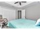This bedroom features a ceiling fan, a spacious closet, a light blue bedspread, and a comfortable chair at 12392 Sw 85 Pl, Dunnellon, FL 34432