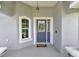 Close-up of the front door, showcasing sidelights, transom window, and welcome mat on the concrete porch at 12392 Sw 85 Pl, Dunnellon, FL 34432
