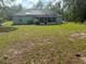 View of a spacious backyard with a screened-in porch and mature trees, offering a private outdoor space at 13155 Sw 73 Ave, Ocala, FL 34473