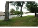 Lush backyard with tall trees and white fence, offering privacy and shade at 14126 Greater Pines Blvd, Clermont, FL 34711