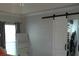 Bedroom featuring a sliding barn door leading to a closet, a large window, and neutral wall color at 14126 Greater Pines Blvd, Clermont, FL 34711
