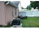 Side yard with equipment and a trailer, all next to a tall privacy fence at 14126 Greater Pines Blvd, Clermont, FL 34711