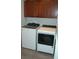 Convenient laundry room features a top loading washing machine and dryer, with upper cabinet storage at 14126 Greater Pines Blvd, Clermont, FL 34711
