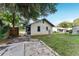 View of the home's backyard with an access door and small green lawn at 1434 Se Silver Springs Pl, Ocala, FL 34471