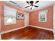 Comfortable bedroom featuring hardwood flooring and two bright windows at 1434 Se Silver Springs Pl, Ocala, FL 34471