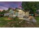 A quaint yellow single-story home is bathed in the soft glow of dusk, surrounded by lush greenery at 1434 Se Silver Springs Pl, Ocala, FL 34471