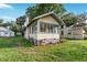 Quaint yellow single-story home featuring a charming sunroom and well-maintained lawn at 1434 Se Silver Springs Pl, Ocala, FL 34471