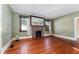 Bright living room featuring original hardwood floors, vintage brick fireplace, and large windows at 1434 Se Silver Springs Pl, Ocala, FL 34471