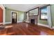 Cozy living room with original hardwood floors, a charming brick fireplace, and inviting natural light at 1434 Se Silver Springs Pl, Ocala, FL 34471