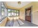 Cozy sunroom with large windows, a ceiling fan, and a door to the main house at 1434 Se Silver Springs Pl, Ocala, FL 34471