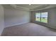 Large bedroom featuring carpet, a tray ceiling, and a window that provides natural lighting at 15055 Sw 25Th Cir, Ocala, FL 34473