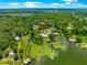 Beautiful aerial view of the waterfront property with the home surrounded by lush greenery and water features at 15621 Se 103Rd Ter, Summerfield, FL 34491