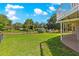 An ample fenced backyard with a green lawn beneath a bright blue sky with scattered fluffy white clouds at 15621 Se 103Rd Ter, Summerfield, FL 34491