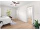 Bright bedroom featuring a ceiling fan, wood-look flooring, and an ensuite bathroom for added privacy and convenience at 15621 Se 103Rd Ter, Summerfield, FL 34491
