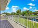 A spacious deck overlooks a manicured lawn, mature trees, and a tranquil pond, enhancing the outdoor experience at 15621 Se 103Rd Ter, Summerfield, FL 34491