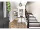 Inviting foyer featuring stone floors, a staircase, and views into the kitchen with white cabinets at 15621 Se 103Rd Ter, Summerfield, FL 34491