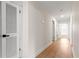 Hallway with light wood floors, white walls, white doors, and views into other rooms at 15621 Se 103Rd Ter, Summerfield, FL 34491