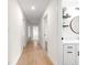Bright hallway featuring wood-look flooring and access to various rooms and the bathroom at 15621 Se 103Rd Ter, Summerfield, FL 34491