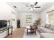 Comfortable living room featuring hardwood floors, a ceiling fan, a sofa, and natural light at 15621 Se 103Rd Ter, Summerfield, FL 34491