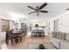 Bright living room and kitchen featuring an open concept with light wood floors and a ceiling fan at 15621 Se 103Rd Ter, Summerfield, FL 34491