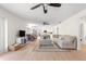 Bright open-concept living room flows into the kitchen with light wood floors and a ceiling fan at 15621 Se 103Rd Ter, Summerfield, FL 34491