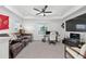 Spacious bonus room with dark leather sofa, desk area, and large screen television at 1814 Nw 44 Court Rd, Ocala, FL 34482