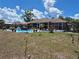 Spacious backyard features a pool, screened-in patio, comfortable seating, and tasteful landscaping at 21511 Sw Plantation Sw St, Dunnellon, FL 34431