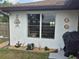 This backyard features a window surrounded by decorative pieces and a charming flower bed at 21511 Sw Plantation Sw St, Dunnellon, FL 34431