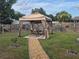 Backyard showcasing a charming gazebo, a dining set, and a quaint gravel pathway at 21511 Sw Plantation Sw St, Dunnellon, FL 34431