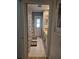 Hallway view of a bathroom with a patterned shower curtain, white tile floors, and vanity at 21511 Sw Plantation Sw St, Dunnellon, FL 34431
