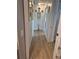 Hallway with wood laminate floors and decorative mirrors and art on the walls at 21511 Sw Plantation Sw St, Dunnellon, FL 34431
