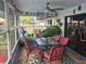 Screened patio with dining table, fan, and view of backyard fountain and tropical foliage at 21511 Sw Plantation Sw St, Dunnellon, FL 34431
