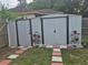 A spacious backyard shed is flanked by symmetrical plant stands and decorative walkway at 21511 Sw Plantation Sw St, Dunnellon, FL 34431